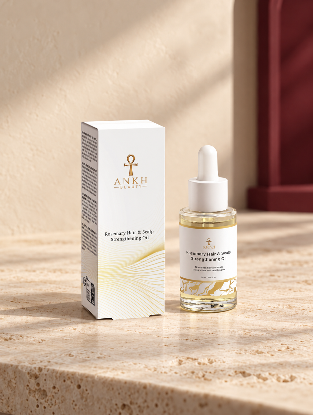 Rosemary Hair & Scalp Strengthening Oil, original Ankh Beauty packaging on warm ivory stone