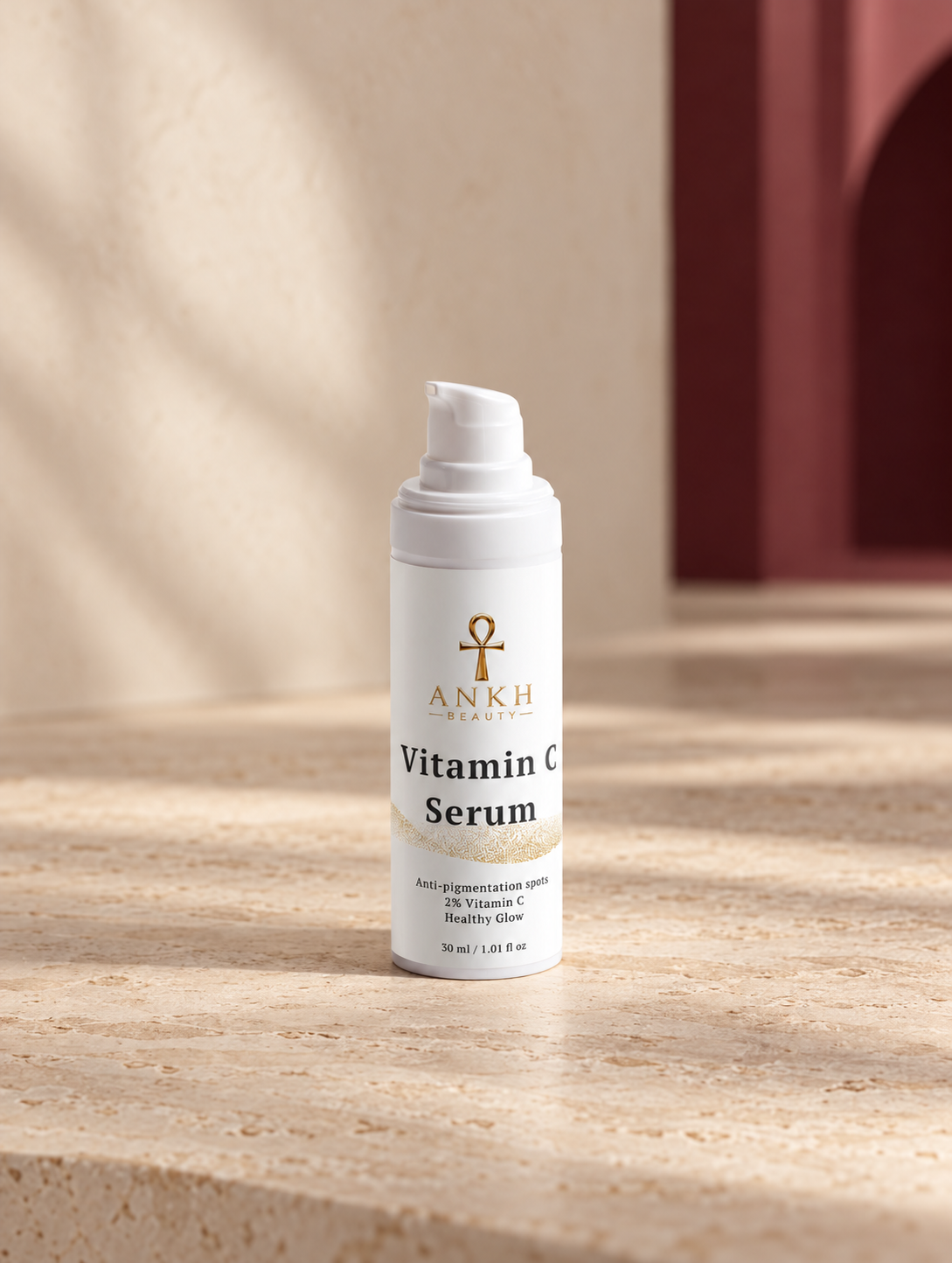 Vitamin C Serum, original Ankh Beauty packaging on warm ivory stone